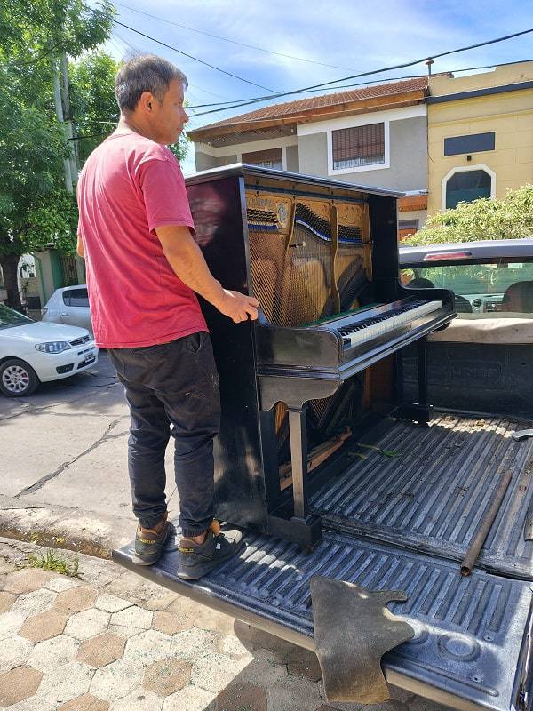 Equipo trasladando un piano